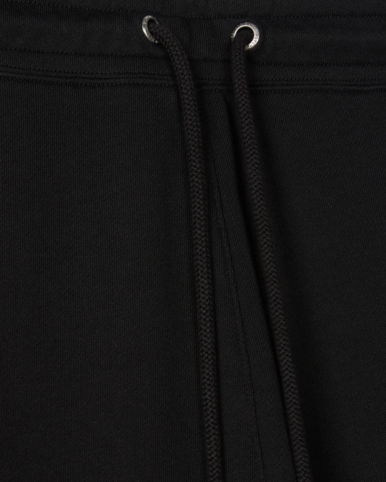 Close-up of black drawstrings on a black garment, likely the Psycho Bunny Men's Pacific Chenille Jogger (B6P972D200), featuring metal eyelets at the top. The fabric appears thick and textured, providing a casual bottom look ideal for everyday wear.
