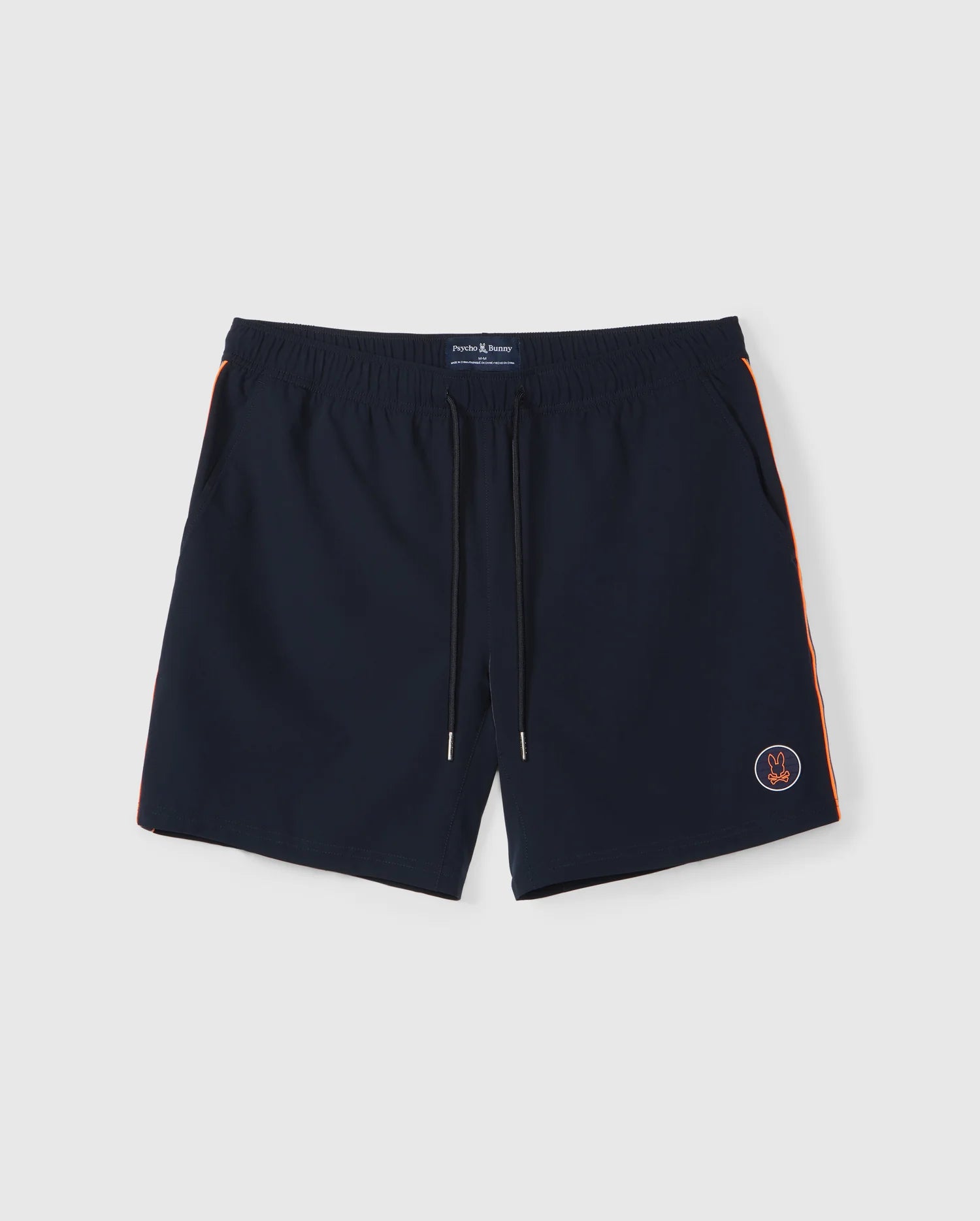The Psycho Bunny MENS SONTERRA STRIPE SPORT SHORT - B6R464C200 are dark blue men's swim trunks made from stretch fabric, featuring a drawstring waistband. They have moisture-wicking properties, orange side stripes, and a small embroidered round logo on the front left leg. The background is plain white.