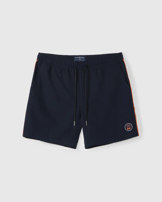 The Psycho Bunny MENS SONTERRA STRIPE SPORT SHORT - B6R464C200 are dark blue men's swim trunks made from stretch fabric, featuring a drawstring waistband. They have moisture-wicking properties, orange side stripes, and a small embroidered round logo on the front left leg. The background is plain white.