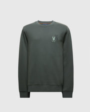The MENS WORDMARK PEACHED TERRY CREW - B6S278E200 by Psycho Bunny is a dark green knit cotton pullover featuring a subtle embroidered graphic of bunnies on the upper left chest area. It has a classic crew neckline, ribbed cuffs, and a plain white background.