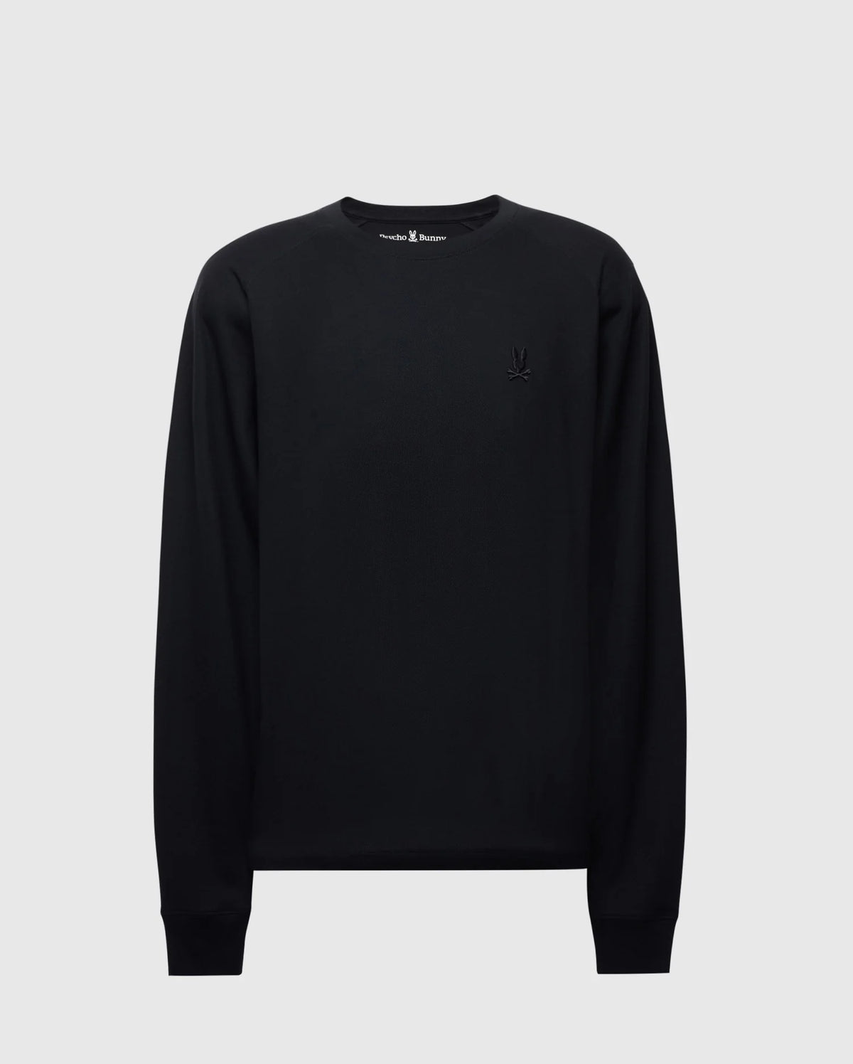 The Psycho Bunny MENS TAYLOR PIQUE LONG SLEEVE TEE (B6T580F200) features a black Pima cotton crew neck design with ribbed cuffs and a small embroidered emblem on the left chest, displayed on a plain light gray background.