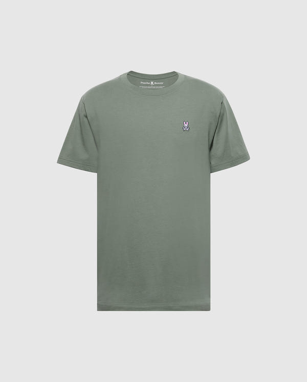 The Psycho Bunny Men's Classic Crew Neck Tee (B6U014B200) is a soft Pima cotton t-shirt in plain green, featuring a small embroidered bunny logo on the left chest. It's showcased against a light gray background, emphasizing its subtle charm.