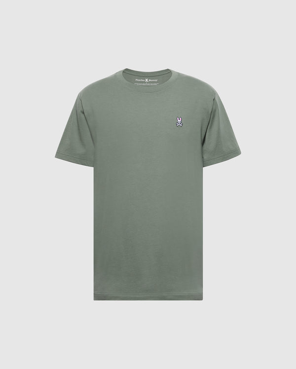 The Psycho Bunny Men's Classic Crew Neck Tee (B6U014B200) is a soft Pima cotton t-shirt in plain green, featuring a small embroidered bunny logo on the left chest. It's showcased against a light gray background, emphasizing its subtle charm.