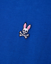 Crafted from luxurious Pima cotton, the Psycho Bunny MENS CLASSIC CREW NECK TEE - B6U014CRPC features a subtle embroidered logo of a rabbit skull with pink ears elegantly perched above crossed bones, creating a striking contrast against the blue fabric.