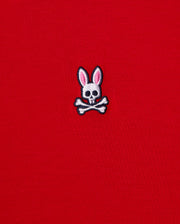 This men's v-neck tee, by Psycho Bunny, features a small emblem of a bunny skull with pink ears and crossbones embroidered on its bright red fabric. It's crafted from premium Pima cotton for exceptional quality. The product is named MENS CLASSIC V NECK TEE - B6U100CRPC.