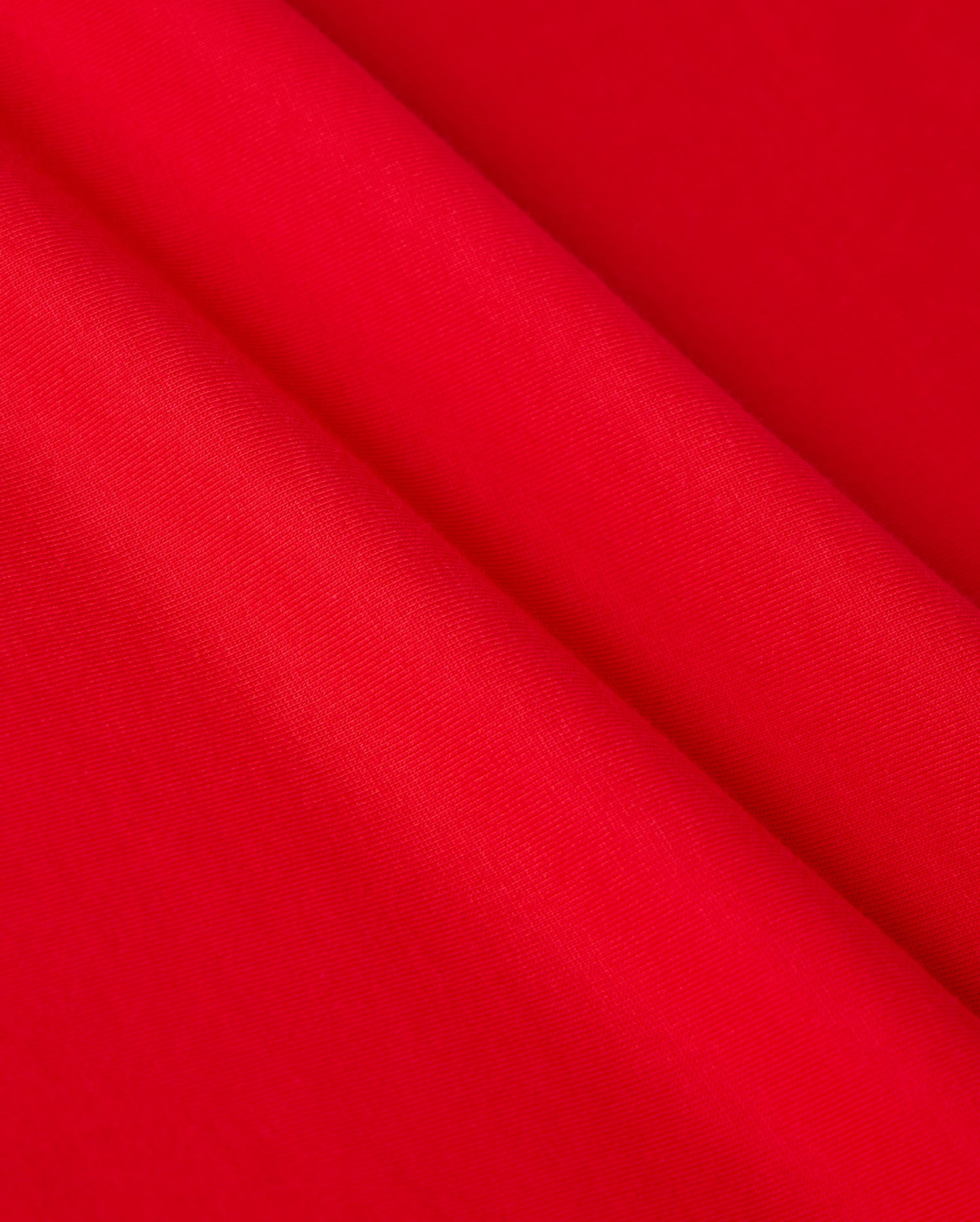Close-up of vibrant red Pima cotton fabric draped in soft folds, showcasing the smooth texture and rich color reminiscent of the MENS CLASSIC V NECK TEE - B6U100CRPC by Psycho Bunny, adorned with the subtle elegance of its logo.