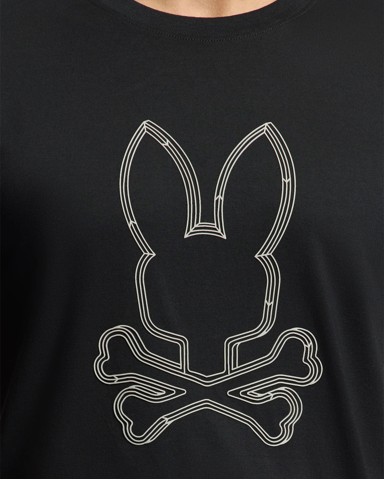 The Psycho Bunny Men's Monarc Front Bunny Graphic Tee (B6U211E200) features a stylized rabbit head with long ears over crossed bones, reminiscent of a classic skull and crossbones design. Made from luxurious Pima cotton, this exclusive black tee combines comfort with edgy style.