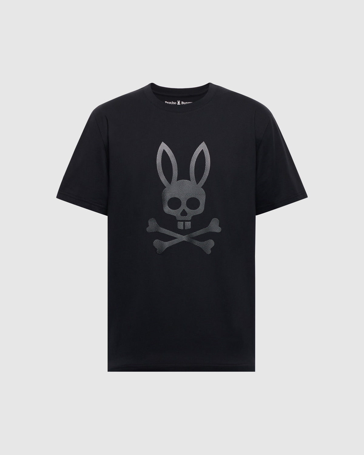 The Psycho Bunny Men's Payson Leather Print Graphic Tee (B6U213E200) is a black Pima cotton jersey tee with short sleeves and a round neckline, featuring a gray leather print of a bunny skull and crossbones on the front.