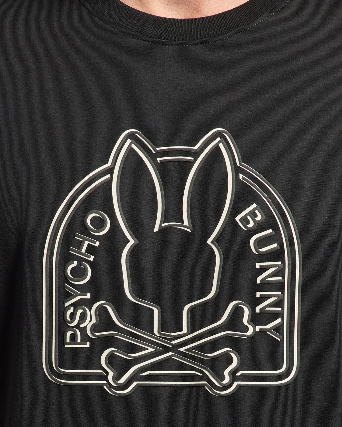 Close-up of the black MENS MELBOURNE GRAPHIC TEE - B6U410F200 by Psycho Bunny, made eco-friendly, featuring the iconic Bunny graphic with a rabbit head silhouette above crossed bones and "Psycho" and "Bunny" vertically on each side.