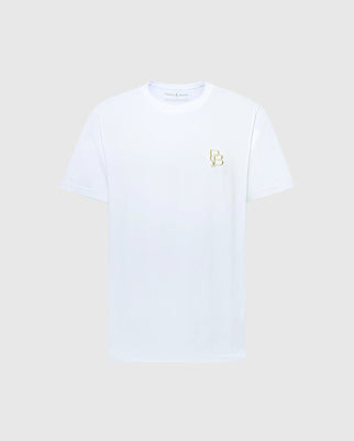 The Psycho Bunny MENS NICHOLSON PB CHEST GRAPHIC TEE - B6U416F200 is a regular fit, plain white short-sleeve shirt made from soft Pima cotton with a subtle gold logo of intertwined letters on the left chest. Displayed against a light gray background, it exudes understated elegance.