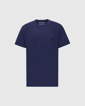 The Psycho Bunny Men's Nicholson PB Chest Graphic Tee (B6U416F200) is a navy blue, Pima cotton crew-neck tee with short sleeves. It features a subtle embroidered logo of overlapping "P" and "B" letters on the left chest, elegantly presented against a plain white background.