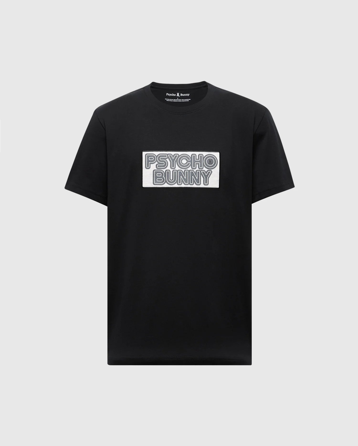The Psycho Bunny MENS SYDNEY WORDMARK GRAPHIC TEE (B6U510F200) is a black Pima cotton short-sleeve shirt with a bold, outlined "PSYCHO BUNNY" white patch graphic on the chest, printed in premium water-based ink.