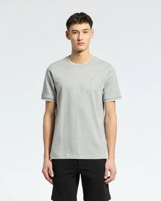 A person faces forward against a plain background wearing Psycho Bunny's MENS MACKAY JACQUARD FASHION TEE - B6U576F200 in light gray and black pants. The Pima cotton T-shirt showcases an embroidered Bunny logo on the left chest.