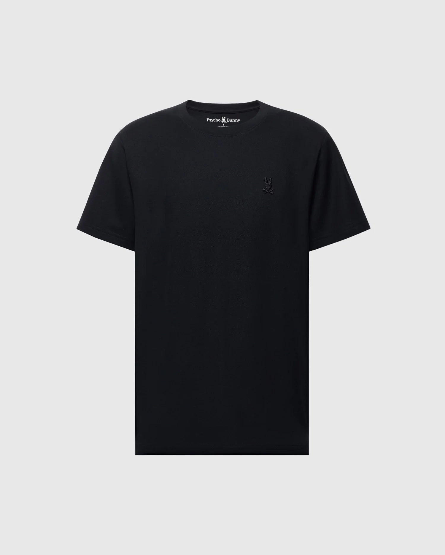 The Psycho Bunny MENS TAYLOR PIQUE TEE - B6U579F200 is a soft black Pima cotton T-shirt with short sleeves and a crew neck. An embroidered Bunny logo subtly accents the left chest, while the light gray background enhances its timeless simplicity.