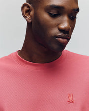 A man in a Psycho Bunny MENS TAYLOR PIQUE TEE (B6U579F200) with an embroidered bunny logo looks down neutrally, showcasing the shirt’s stylish silhouette against a plain background.