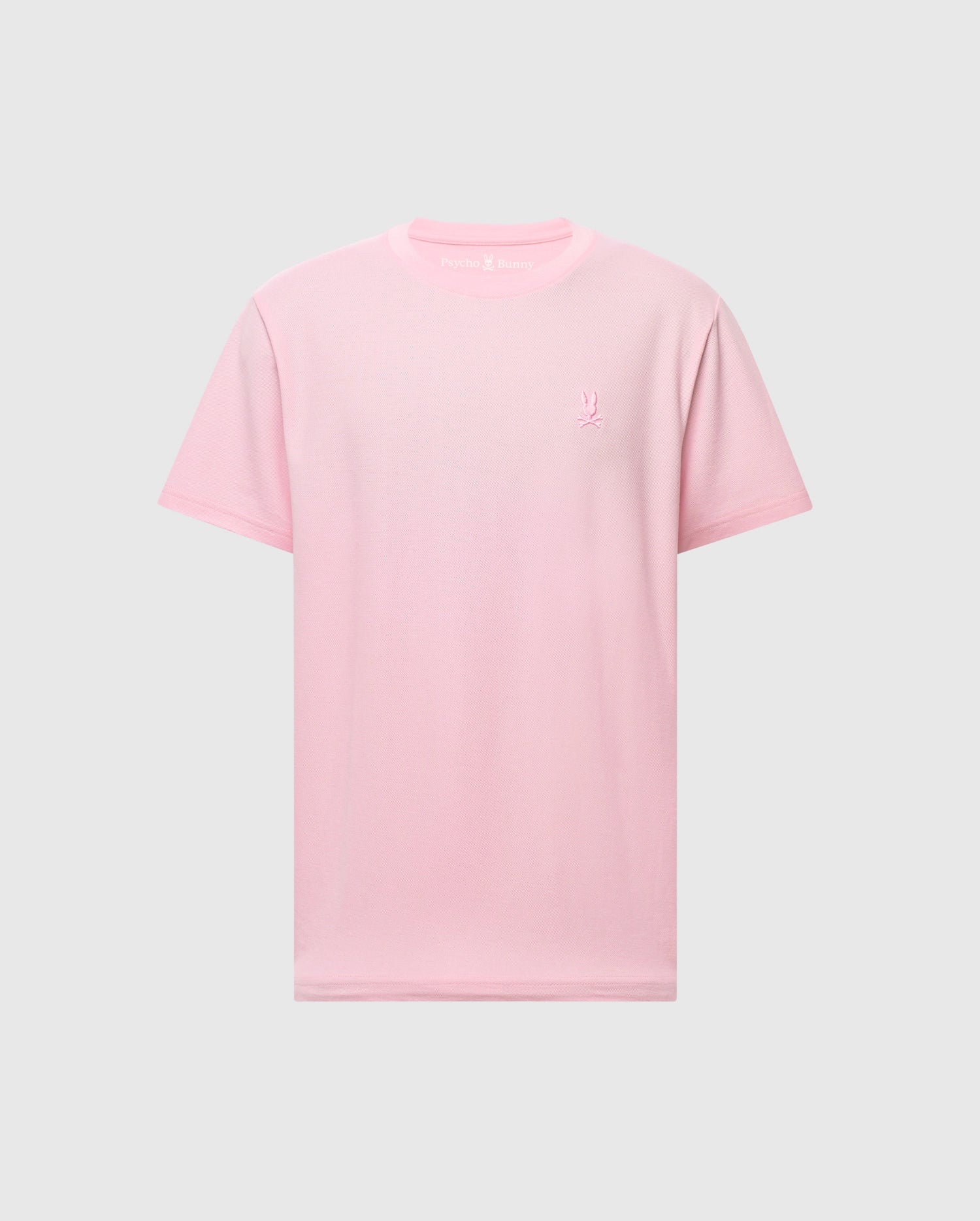 The Psycho Bunny MENS TAYLOR PIQUE TEE (B6U579F200) is a light pink Pima cotton short-sleeve tee with a small embroidered Bunny logo on the left chest, shown on a light gray background.