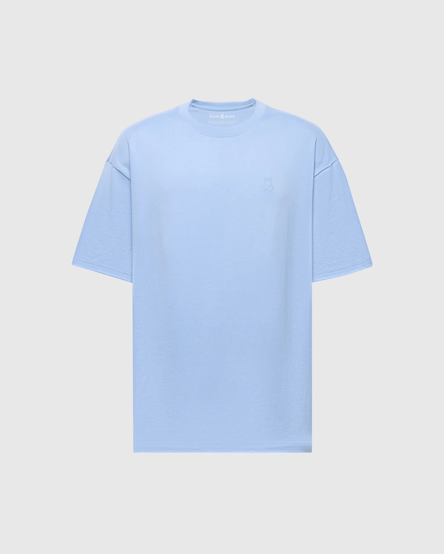 The Mens Duke Heavy Weight Relaxed Fit Tee by Psycho Bunny is a light blue, short-sleeve T-shirt made from luxurious Pima cotton. It features a subtle embroidered design on the top left and comes with a plain gray background.