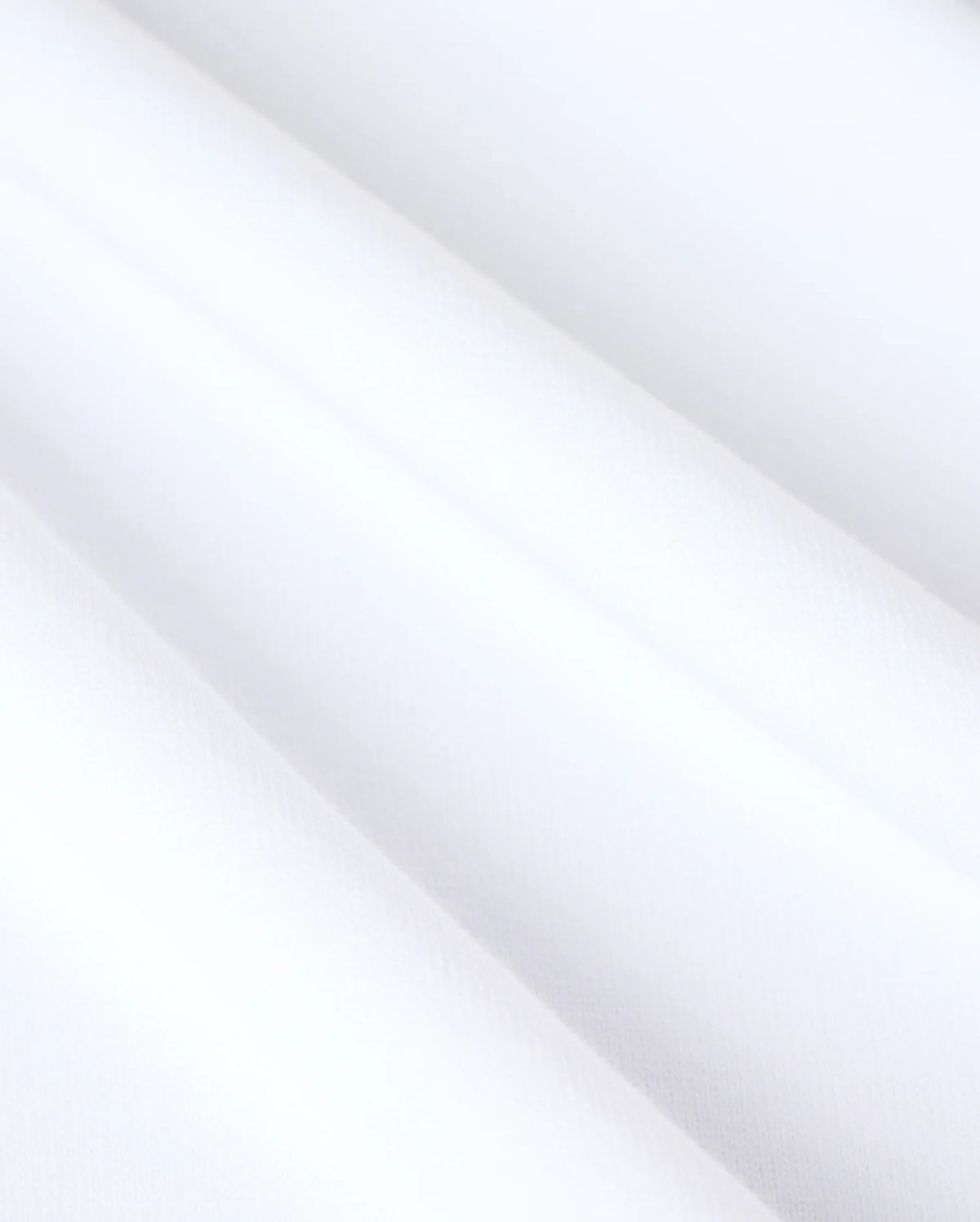 Close-up image of the MENS DUKE OVERSIZED TEE - B6U742D200 by Psycho Bunny, showcasing its relaxed fit and smooth, heavyweight Pima cotton. The fabric displays soft, diagonal folds, emphasizing its refined and clean appearance.