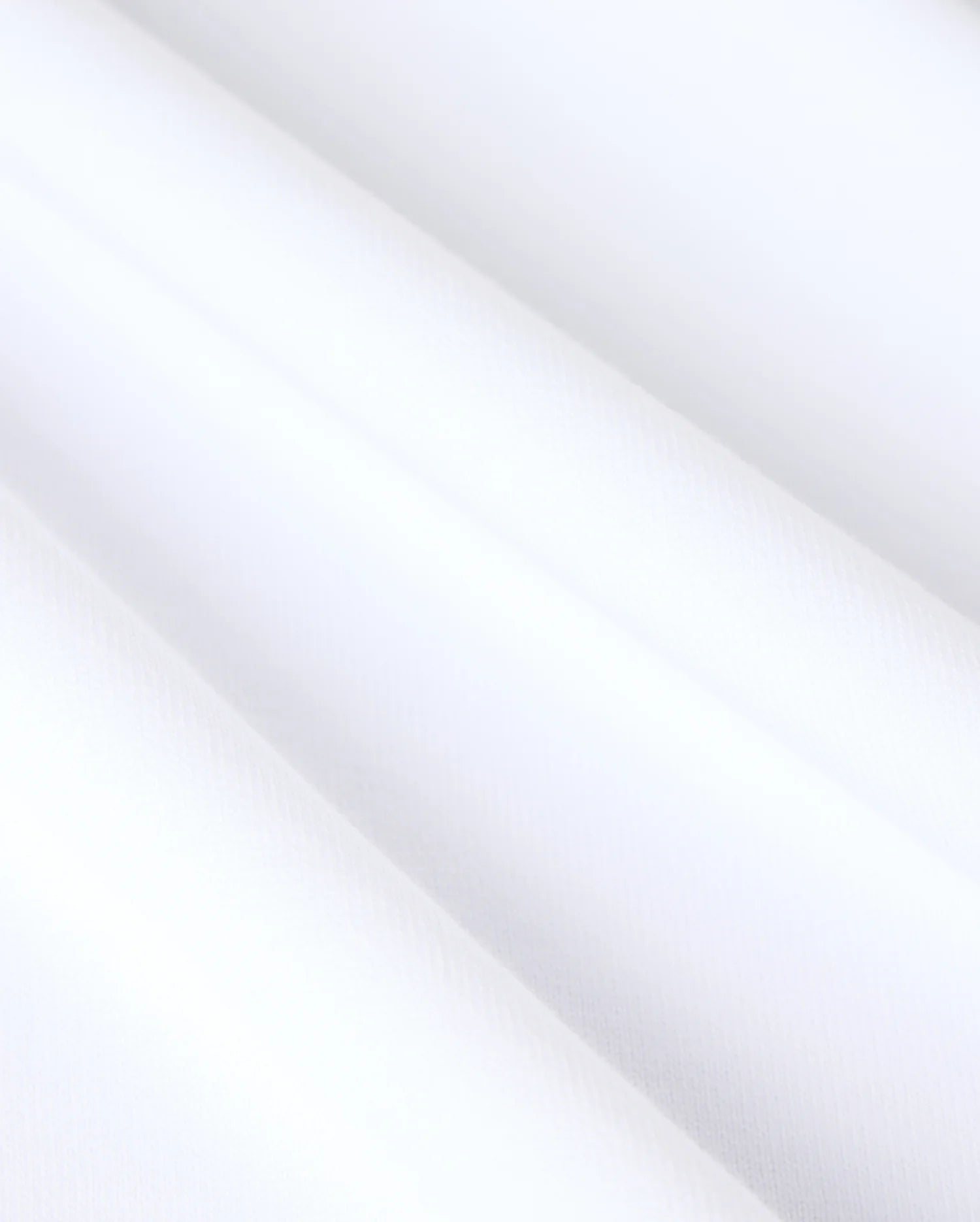 Close-up image of the MENS DUKE OVERSIZED TEE - B6U742D200 by Psycho Bunny, showcasing its relaxed fit and smooth, heavyweight Pima cotton. The fabric displays soft, diagonal folds, emphasizing its refined and clean appearance.