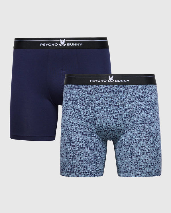The MENS 2 PACK BOXER BRIEF - B6V481F200 by Psycho Bunny includes two pairs: one in solid navy and the other with a blue logo pattern. Made from premium Pima cotton stretch, both feature black waistbands with the Psycho Bunny logo in white.