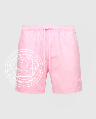 Psycho Bunny MENS SAMOS HYDROCHROMIC PRINTED SWIM TRUNK (B6W453F200): Light pink swim shorts with a subtle bunny pattern, drawstring waist, side pockets, and water-activated hydrochromic fabric for a unique look.