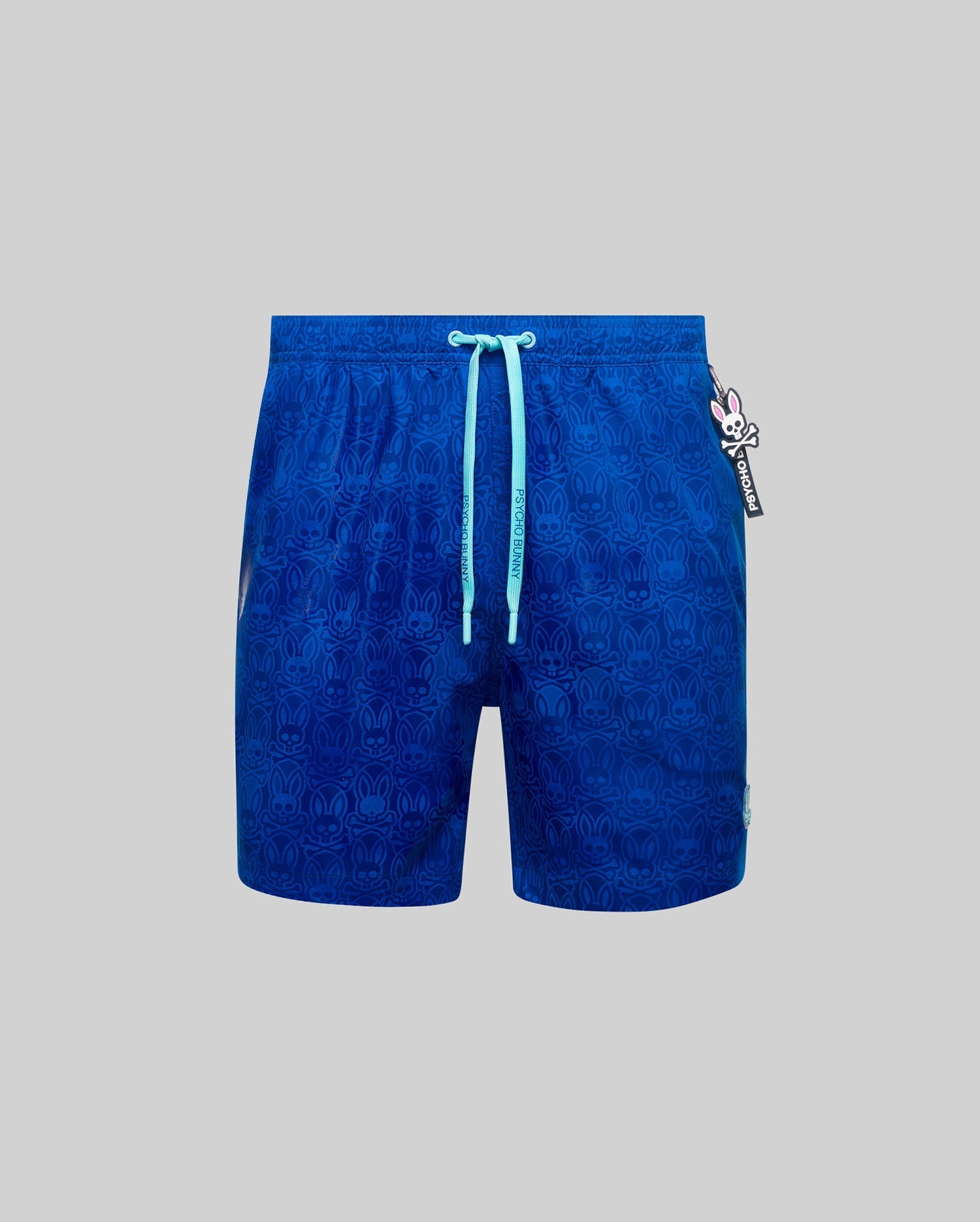 Mens Samos Hydrochromic Printed Swim Trunk in royal blue, featuring an all-over subtle hydrochromic bunny skull pattern, light blue drawstrings with Psycho Bunny text, and a classic fit.