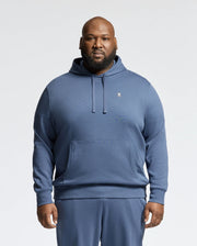 A man stands facing forward against a plain light background, wearing the Psycho Bunny MENS BIG AND TALL LEVY ESSENTIAL FLEECE HOODIE - B9H859D200 and matching blue cotton sweatpants.