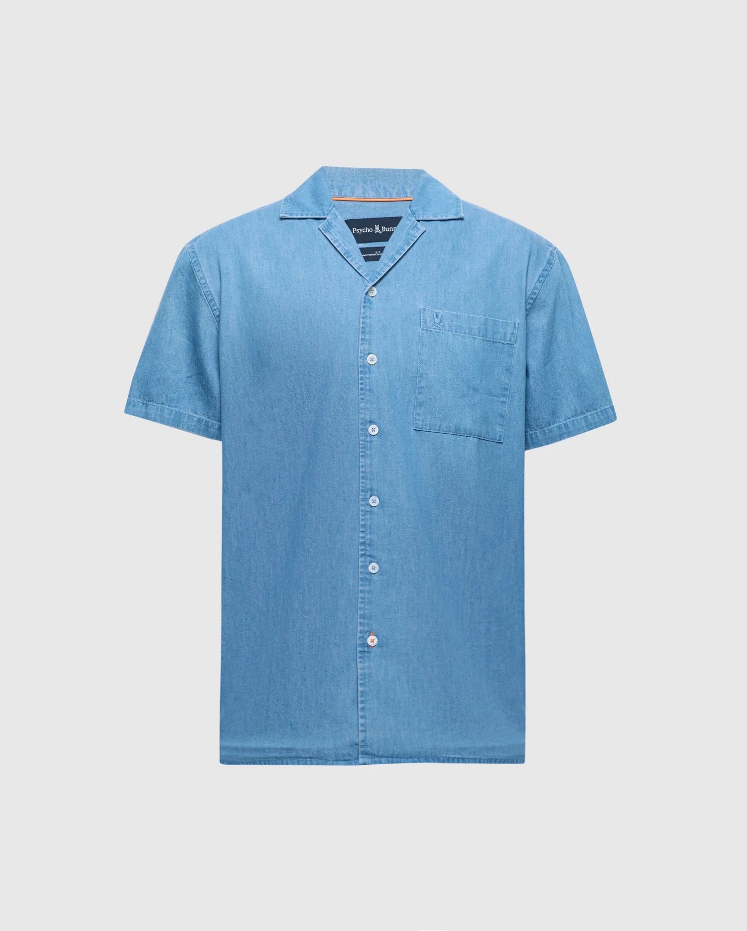 The Psycho Bunny MENS BIG AND TALL KERVIN LIGHTWEIGHT DENIM WOVEN SHIRT (B9Q467F200) is a light blue, short-sleeved shirt with a collar and chest pocket, crafted for comfort and style. Shown against a plain white background.