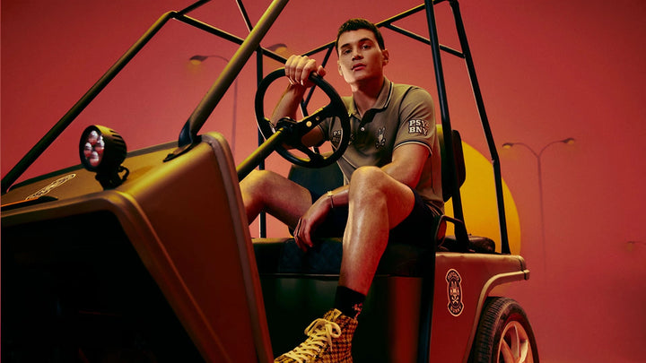 Person sitting on a vintage car with a red background