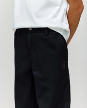 A child wears Psycho Bunny's KIDS MATHIEU COMMUTER PANT (KB0600002) with signature Bunny embroidery on the pocket and a white shirt, standing with hands in pockets.