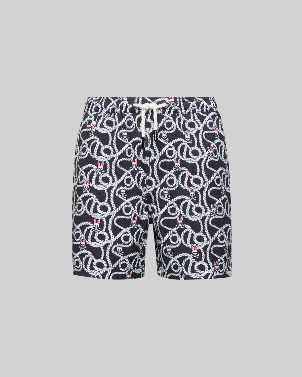Psycho Bunny KIDS CYRUS ALL OVER PRINT SWIM TRUNK - KB1000001: Black quick-dry seersucker swim trunks with a white snake print and red accents, elastic waistband, and white drawstring, shown on a gray background for effortless coastal style.