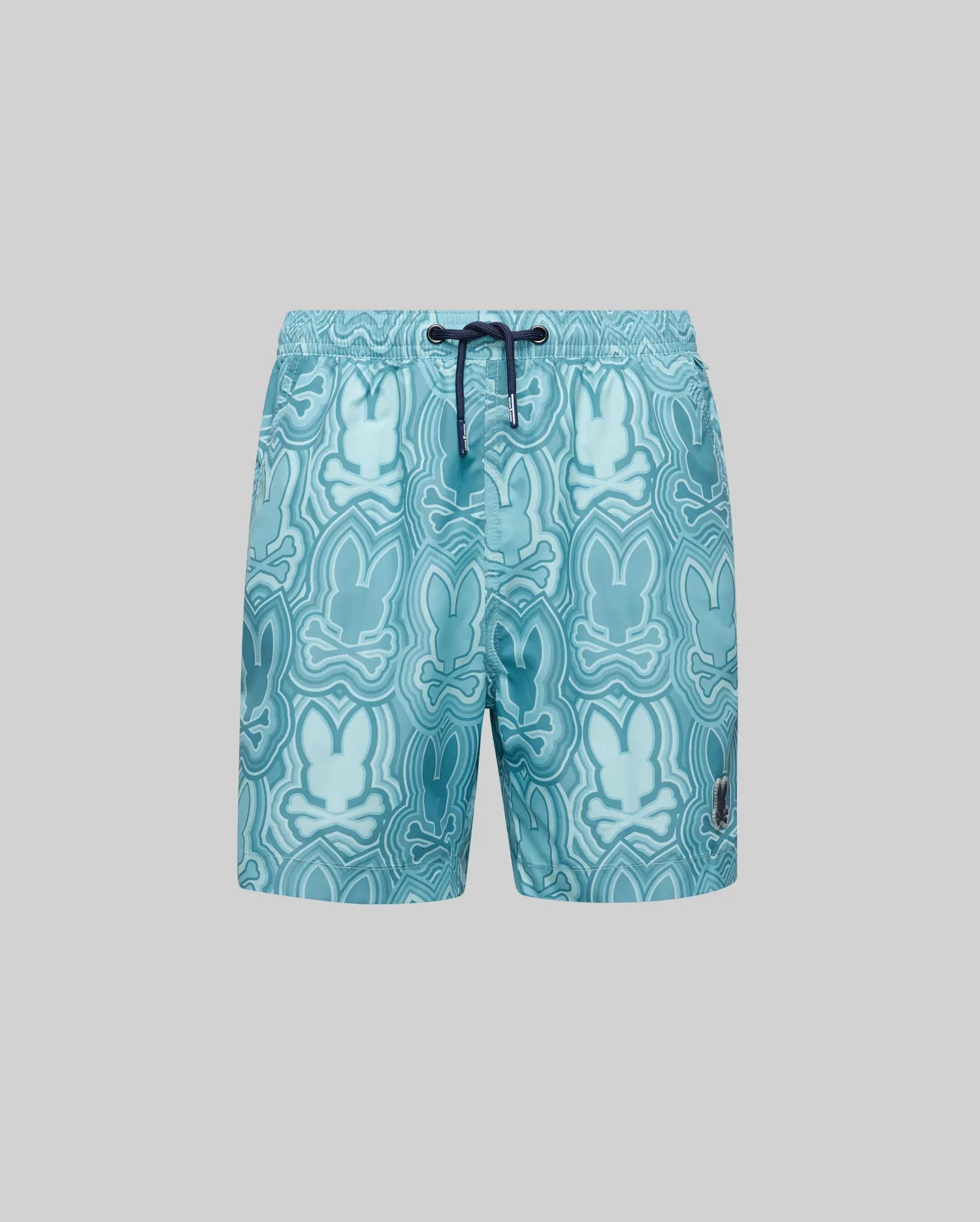 The Psycho Bunny KIDS CHUCK ALL OVER PRINT LIGHTWEIGHT SWIM TRUNK (KB1000002) features recycled polyester in light blue, a dark blue drawstring, and an abstract Bunny print in various blue shades on gray.