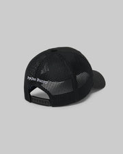 The KIDS DARIO TRUCKER CAP (KO1500009) by Psycho Bunny is shown from the back, featuring black mesh, an adjustable snap-back closure, and "Psycho Bunny" embroidered in white above the opening, set against a plain gray background.