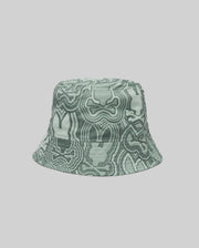 The Psycho Bunny KIDS CHUCK REVERSIBLE BUCKET HAT (KO1500015) with an abstract wavy green and white design is shown on a plain light gray background.