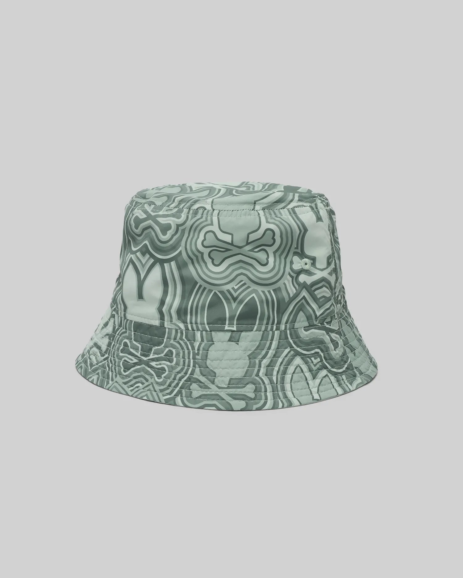 The Psycho Bunny KIDS CHUCK REVERSIBLE BUCKET HAT (KO1500015) with an abstract wavy green and white design is shown on a plain light gray background.