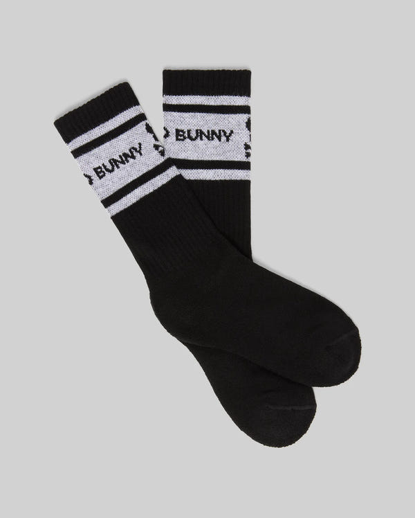 A set of KIDS 3 PACK SPORT SOCK (KO2200001) by Psycho Bunny, black crew socks in soft Pima cotton-blend with white stripes and "BUNNY" in black on the stripes, displayed on a light gray background.