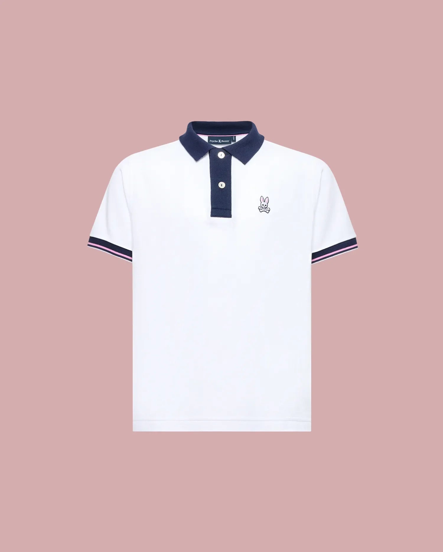 The Psycho Bunny KIDS ARCHIVE CLASSIC BUNNY PIQUE POLO (KT0100010) is a white, short-sleeve Pima cotton shirt with a navy collar and trim, three dark buttons, and an embroidered Bunny logo on the left chest, shown on a pale pink background.
