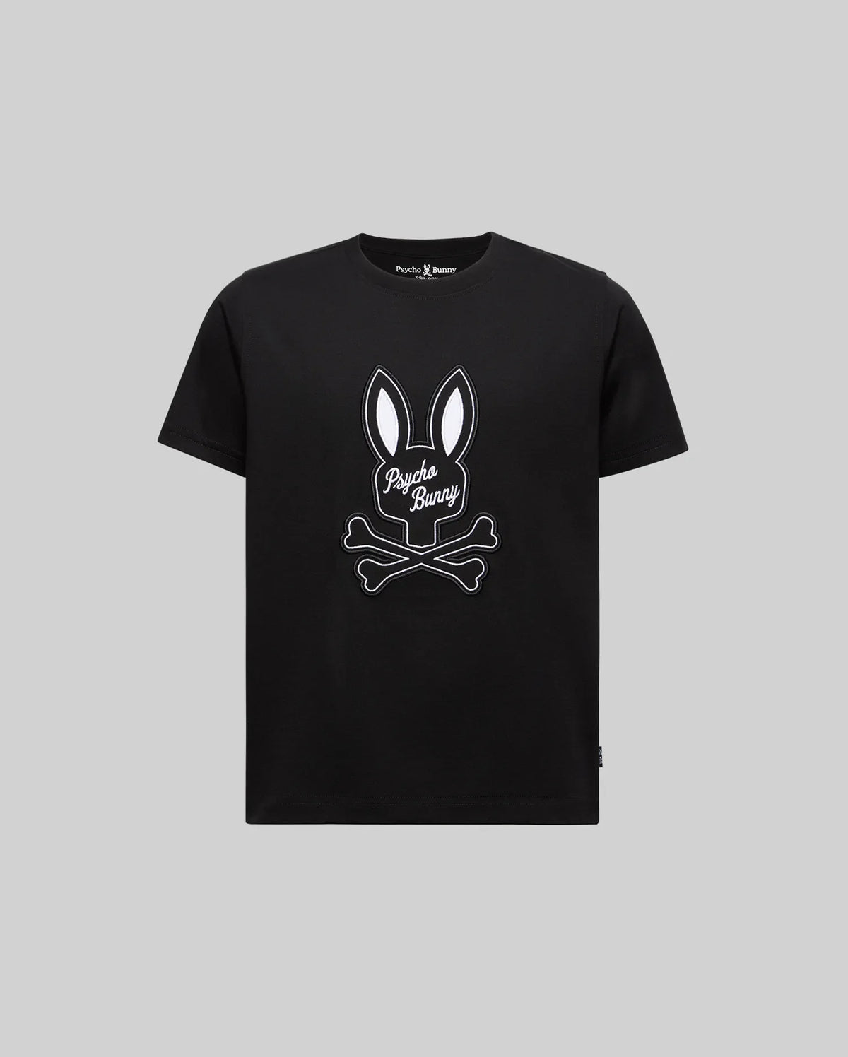 The KIDS DEREK CENTER GRAPHIC TEE (KT0200006) by Psycho Bunny features a soft black Pima cotton design with a white bunny ears and crossed bones graphic, plus "Psycho Bunny" in script on the front, shown on a plain grey background.