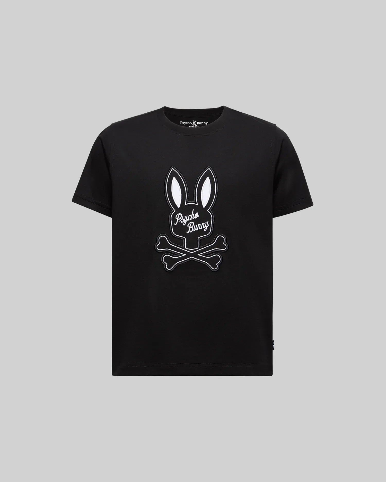The KIDS DEREK CENTER GRAPHIC TEE (KT0200006) by Psycho Bunny features a soft black Pima cotton design with a white bunny ears and crossed bones graphic, plus "Psycho Bunny" in script on the front, shown on a plain grey background.