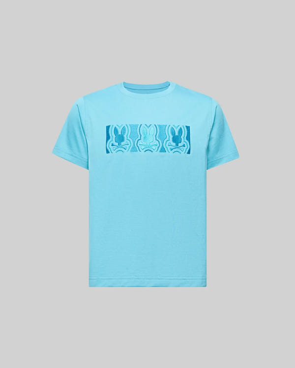 The Psycho Bunny KIDS ROB GRAPHIC TEE (KT0200007) is a light blue Pima cotton shirt with a rectangular chest graphic showing three abstract blue bunny figures on a plain gray background.