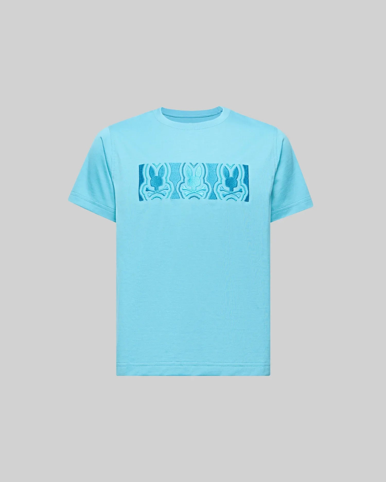 The Psycho Bunny KIDS ROB GRAPHIC TEE (KT0200007) is a light blue Pima cotton shirt with a rectangular chest graphic showing three abstract blue bunny figures on a plain gray background.