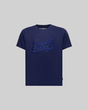 The KIDS ELIAS GRAPHIC TEE (KT0200013) by Psycho Bunny is a navy blue Pima cotton t-shirt featuring bold "Psycho Bunny" script embroidery on the chest in a retro style, displayed on a plain grey background.