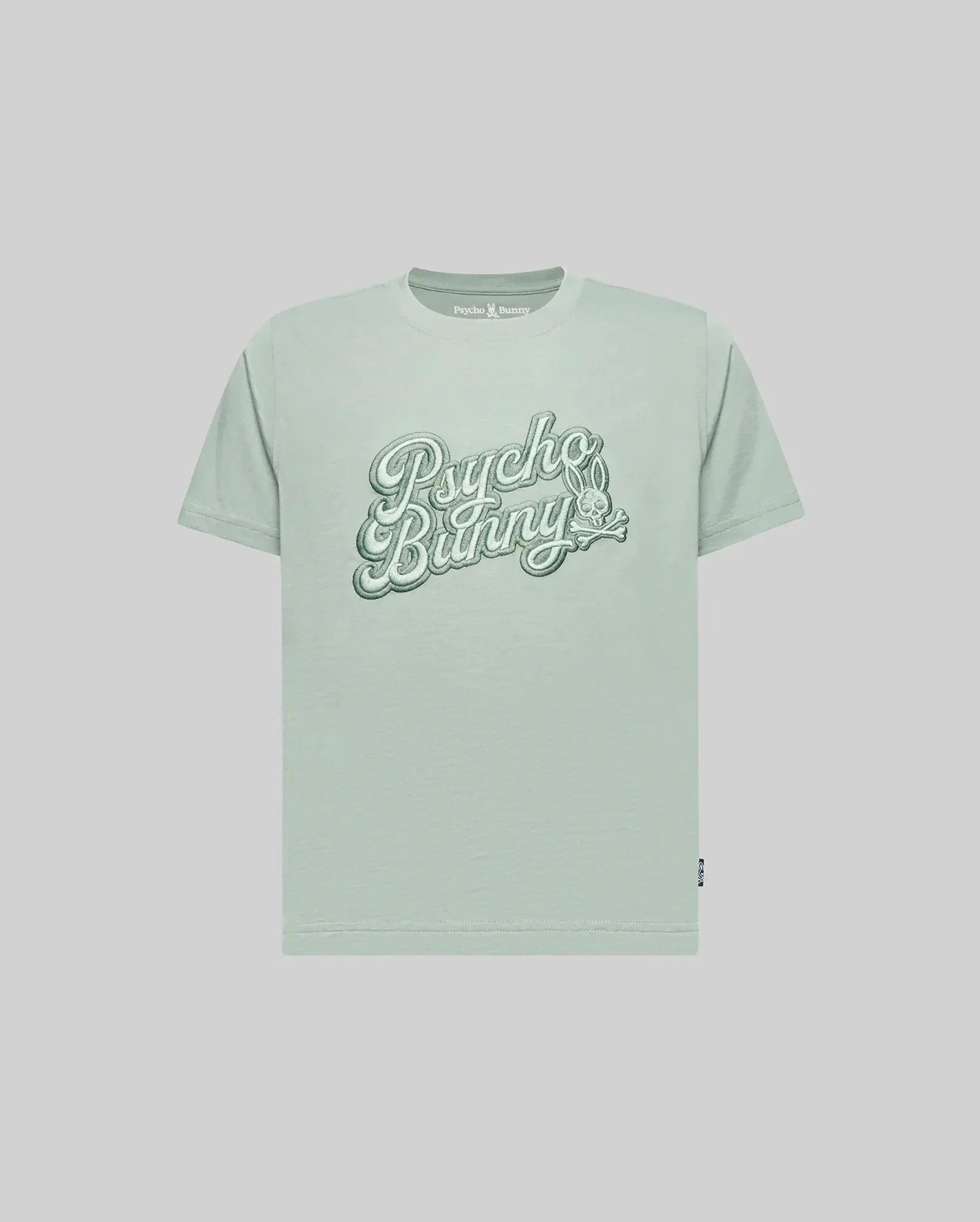 The KIDS ELIAS GRAPHIC TEE (KT0200013) by Psycho Bunny is a light green Pima cotton short-sleeve shirt with large retro "Psycho Bunny" script and a small bunny graphic on the chest, shown against a plain light background.