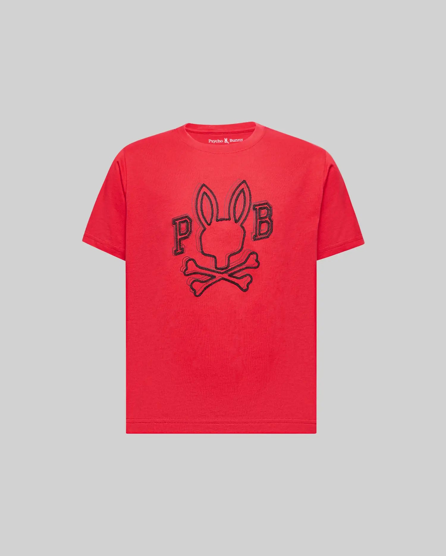 The Psycho Bunny KIDS BALES GRAPHIC TEE (KT0200021) is a red Pima cotton shirt with a bold black outline rabbit-head-and-crossbones graphic, flanked by “P” and “B,” shown on a plain gray background. Perfect for year-round wear.
