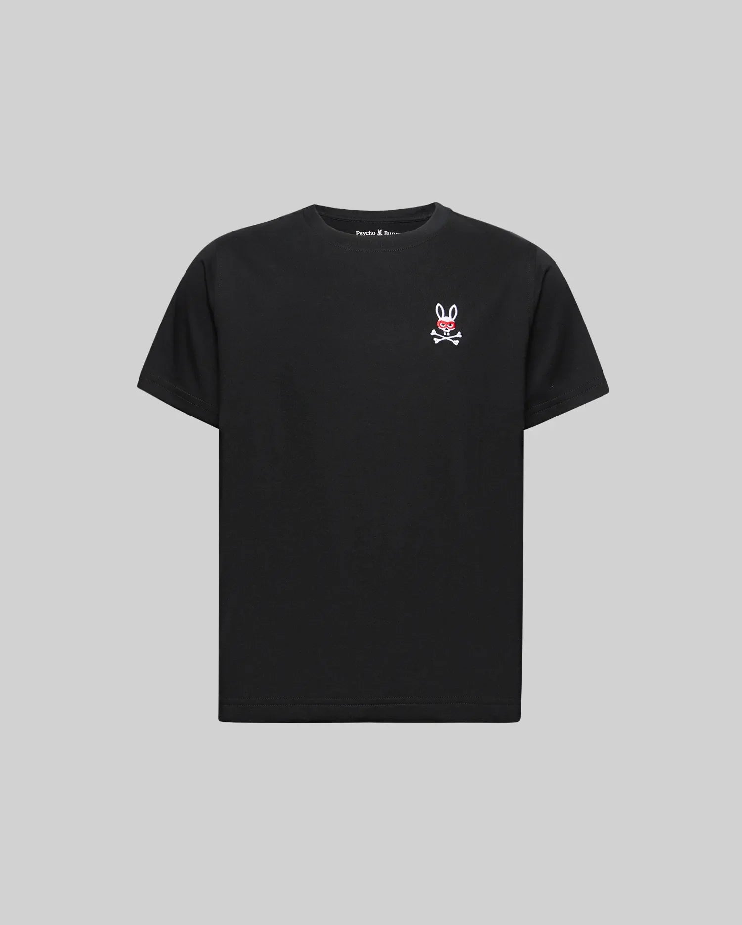 The KIDS MISCHIEF BUNNY TEE (KT0200023) by Psycho Bunny is a black short-sleeve Pima cotton shirt with a small embroidered Mischief Bunny skull-and-crossbones logo on the left chest, shown against a plain gray background.