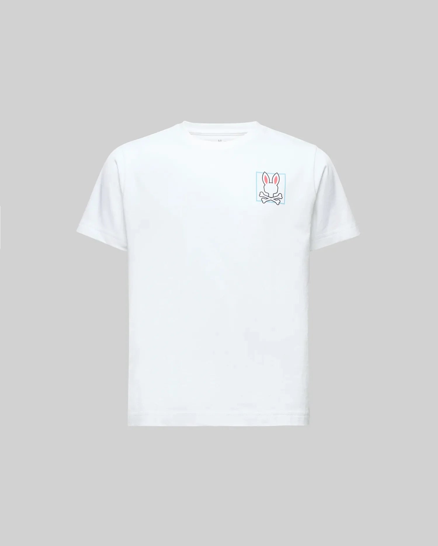 The Psycho Bunny KIDS JESSE GRAPHIC TEE (KT0200031) is a white Pima cotton short-sleeve, featuring a pink-outlined bunny and crossbones graphic on the left chest with eco-friendly water-based prints, shown on a gray background.
