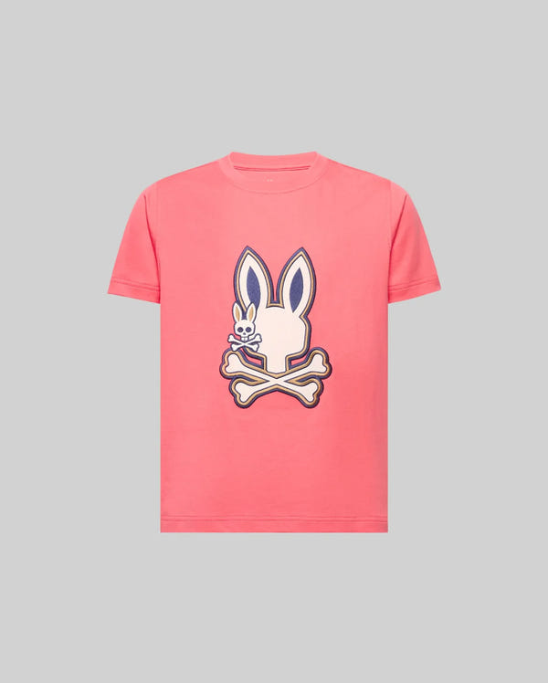 The Psycho Bunny KIDS WADE GRAPHIC TEE (KT0200054) is a pink, 100% cotton short-sleeve shirt featuring a large bunny head above crossed bones and an embroidered Bunny with a bone on a plain gray background.