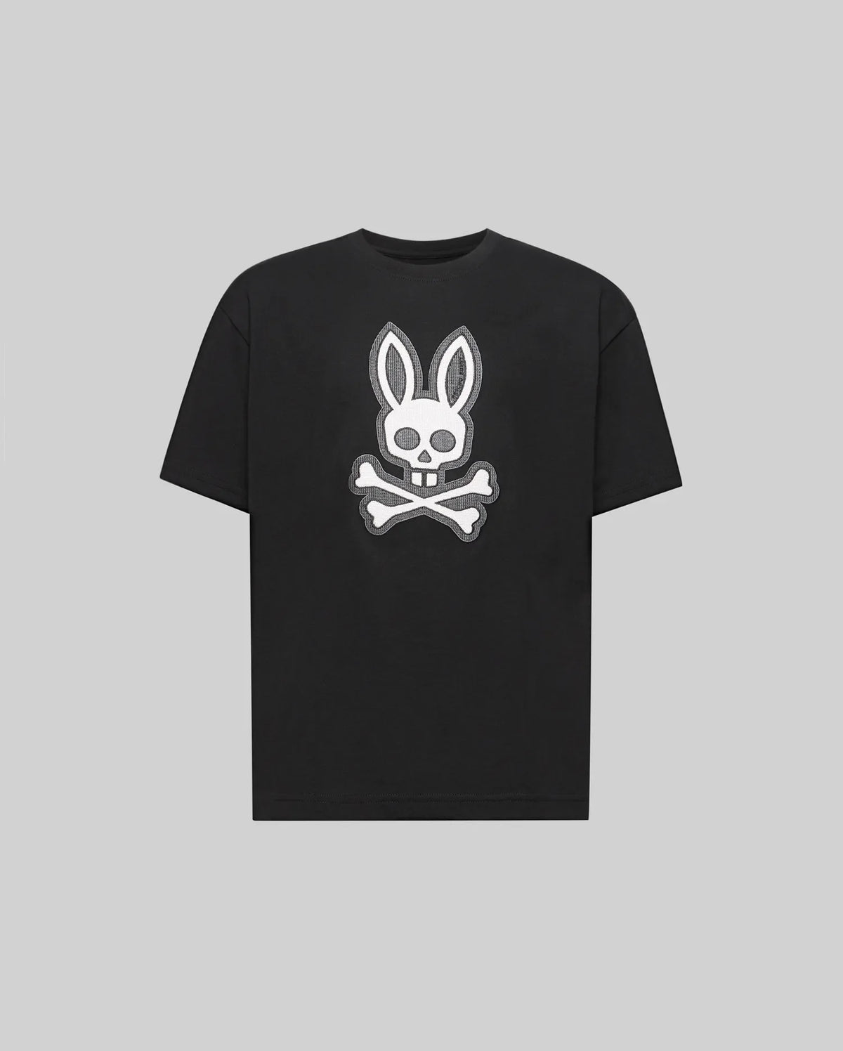 The Psycho Bunny KIDS RYDER OVERSIZED FIT TEE (KT0200056) is a black premium tee crafted from soft Pima cotton, featuring a white embroidered Bunny skull with bunny ears above crossed bones against a gray background.