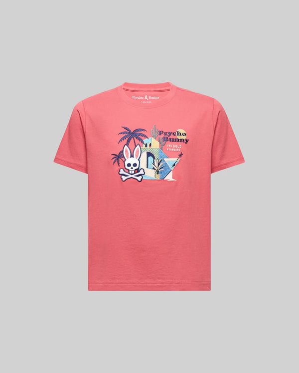 The Psycho Bunny KIDS SHANE GRAPHIC TEE (KT0200090) is a pink Pima cotton short-sleeve shirt with a vibrant cartoon bunny, palm trees, and buildings graphic plus "Psycho Bunny" on the chest, shown on a plain gray background.