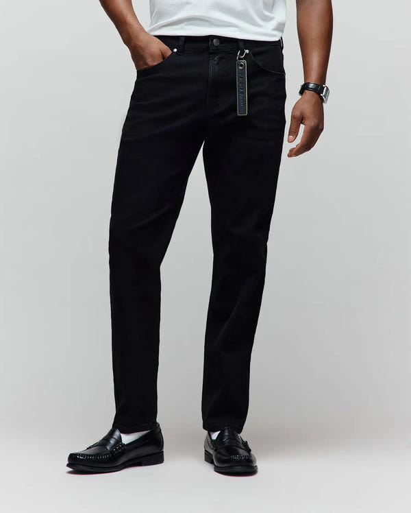 Black Mens Emerson Denim Pant, classic fit, with a visible denim texture and a vibrant green Psycho Bunny keychain attached to the front belt loop.
